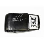 MIKE TYSON; a signed Everlast boxing glove.  Additional Information Creasing and light general