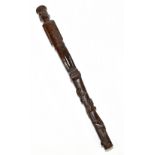 A carved wood section possibly from a walking cane or swagger stick with figural upper section and