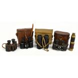 Four pairs of early to mid-20th century black lacquered binoculars including two military issued