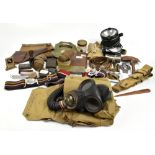 A mixed group of militaria including gasmask in case, belts, a gun cleaning kit, anti-gas eye