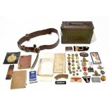 A mixed group of militaria including an ammunition tin, a leather belt, various badges, buttons,