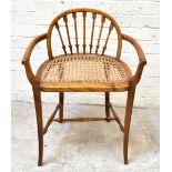 An early 20th century stained beech caned seat chair, the back splats modelled as seven arrows, on
