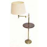 A contemporary brass adjustable standard lamp with mahogany circular tray to the centre, height