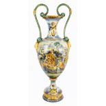 A large 19th century twin handled majolica urn vase, with serpent handles decorated with Cupid and