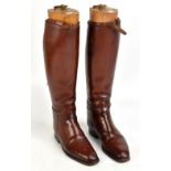 A pair of brown leather hunting boots, with buckle strap tops and sectional boot trees, height 48cm,