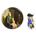 A 19th century ceramic wall charger depicting a girl clutching a priest beside an elderly lady in