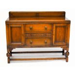 A 1920’s oak sideboard, with three drawers and two cupboard doors, on turned and block legs,