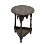 A mid-20th century carved oak cricket table, the circular top raised on triangular shaped body