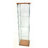 A modern glass display cabinet with three shelves, on plinth base, height 104cm, width 43cm, depth