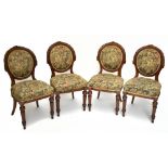 A set of four Victorian carved walnut dining chairs, with floral upholstered backs and seats, on