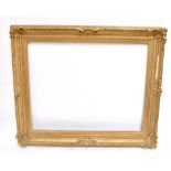 A 19th century carved giltwood and gesso picture frame, the aperture 100 x 128.5cm, overall 136 x