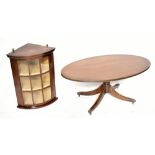 A reproduction mahogany hanging corner cabinet, 67cm high, with an oval coffee table and a wall