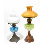 An early 20th century oil lamp, with milk glass shade with relief decoration, with blue glass