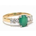 A 9ct yellow gold dress ring set with central green stone flanked on each side by two white