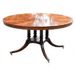 A Regency style mahogany circular dining table with radially veneered top on four turned columns and