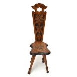 A late Victorian carved oak spinner's chair, the pierced back with foliate detailing above a