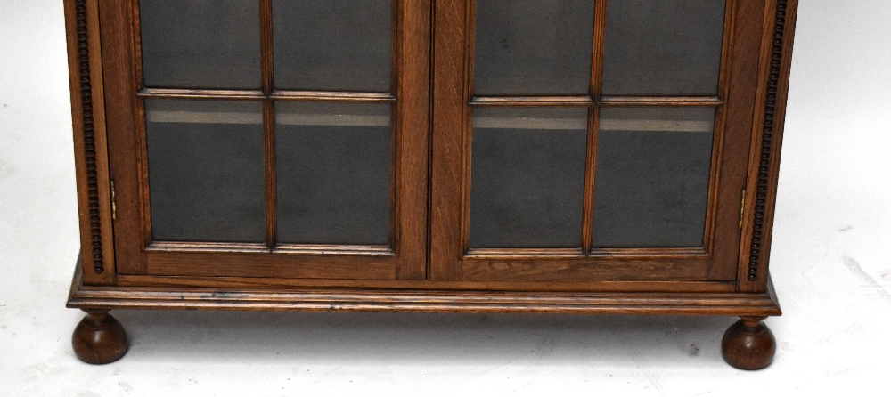 An early 20th century oak bookcase, with two astragal glazed doors, on bun feet, height 110cm, width - Bild 2 aus 6