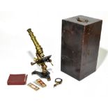 A late 19th century lacquered brass monocular microscope with adjustable circular mirror on
