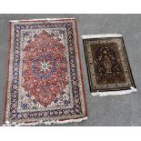 An Eastern silk and wool rug with a central floral motif flanked by scrolling floral panels, in