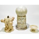 A carved alabaster lamp, modelled with three cherubs, 24cm high, with a smaller alabaster pedestal