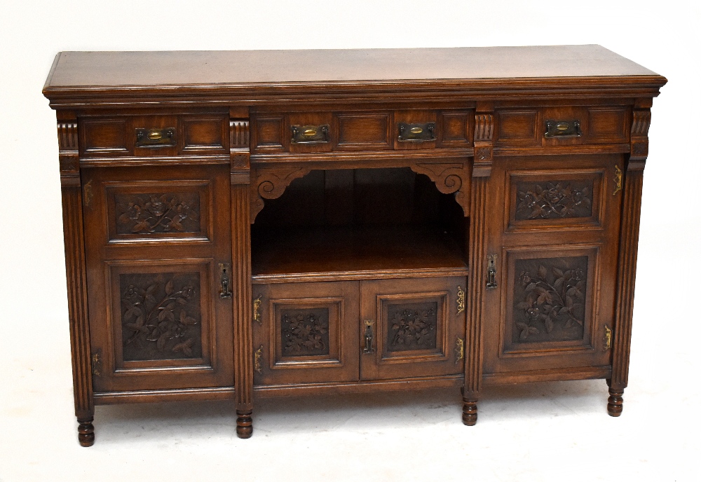 A Victorian Arts & Crafts oak sideboard with three panelled drawers and four panelled cupboard doors