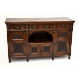 A Victorian Arts & Crafts oak sideboard with three panelled drawers and four panelled cupboard doors