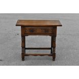 A 17th century style carved and stained oak side table, with drawer, on turned and block legs,