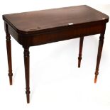 A George III mahogany fold-over table to tapering turned supports and peg feet,