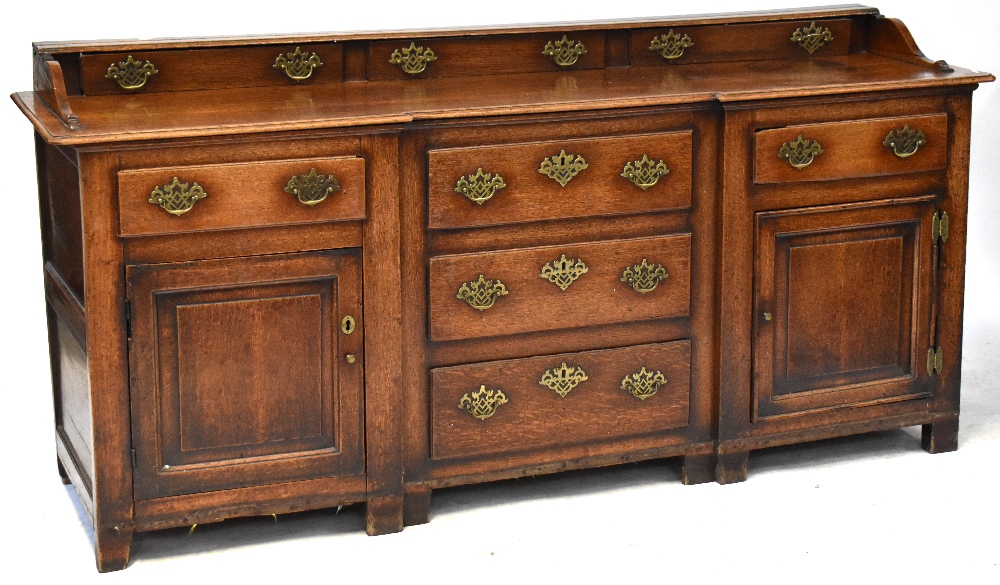 A George III style oak break-front sideboard comprising galleried back of three drawers above