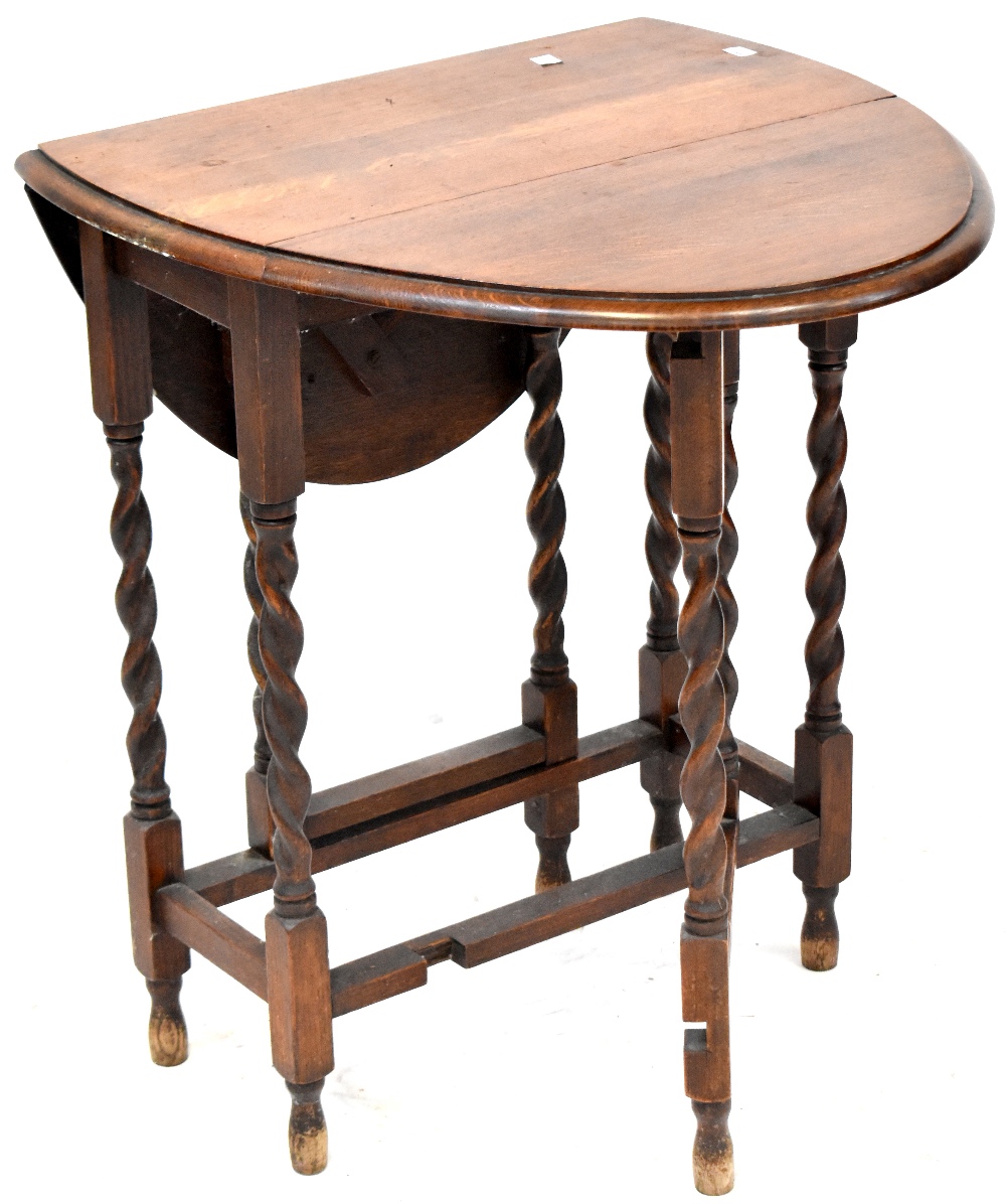 An early 20th century oak drop-leaf gateleg table with wrythen supports and stretchers,