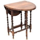 An early 20th century oak drop-leaf gateleg table with wrythen supports and stretchers,