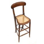 A Victorian child's correction chair with curved top rail, open back, lattice weave seat,