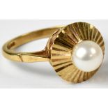 A 9ct gold ring set with a single pearl in a sunburst-style surround, size N, stamped '375',