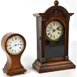 An Edwardian mahogany and boxwood strung balloon shaped mantel timepiece raised on four brass feet,