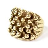 A 9ct yellow gold gentlemen's dress ring with raised lattice and ball decoration to the top, size S,