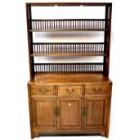A 20th century Chinese hardwood dresser with three open shelves with spindle back racks above a