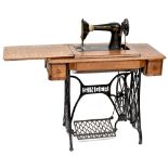 An oak cased Singer treadle sewing machine on cast iron base.
