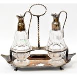 A George III hallmarked silver oil and vinegar condiment set with boat-shaped stand,