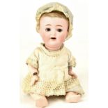 An early 20th century Japanese small bisque headed doll, with open-and-close eyes,