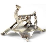 A Peruvian silver model of an alpaca with a gentleman standing behind,