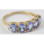 A 9ct yellow gold ring set with five tanzanites, size L, approx 2g.