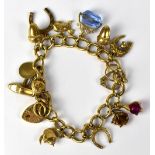 A 9ct gold curb link charm bracelet set with thirteen charms, with a 9ct gold hallmarked padlock,