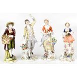 A pair of Sitzendorf figures of a gentleman and lady, each with a lamb at their feet,