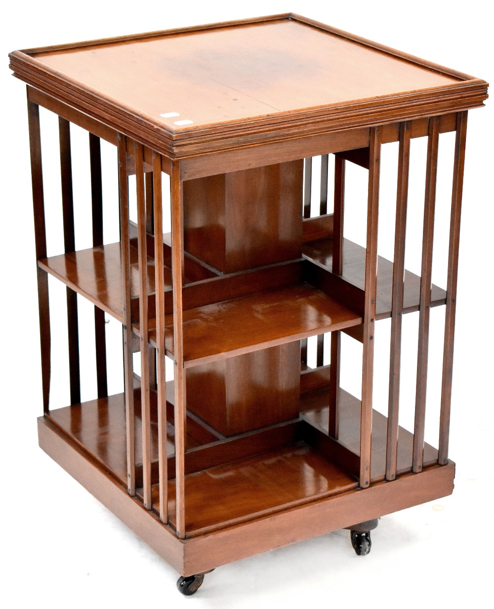 An Edwardian walnut revolving bookcase to baluster supports and castors, 82 x 53 x 53cm.