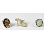 Three silver ladies' dress rings comprising a wide band with ornately set oval faceted smoky quartz