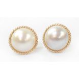 A pair of 9ct gold mounted Mabe pearl earrings, the pearl centres with rope twist borders,