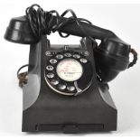 A vintage black bodied Bakelite telephone with drawer to base and bearing plaque inscribed,