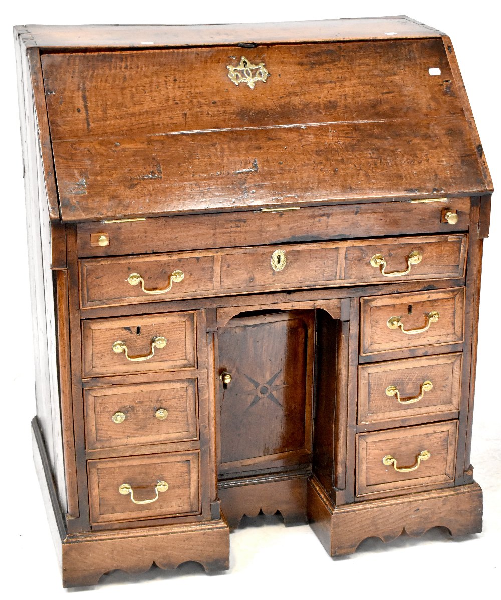 A George III oak bureau, drop-down desk top,