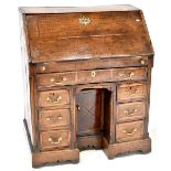 A George III oak bureau, drop-down desk top,