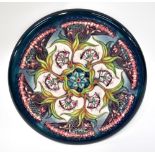 MOORCROFT; a modern charger decorated with a repeating pattern of floral bouquets of wild flowers,